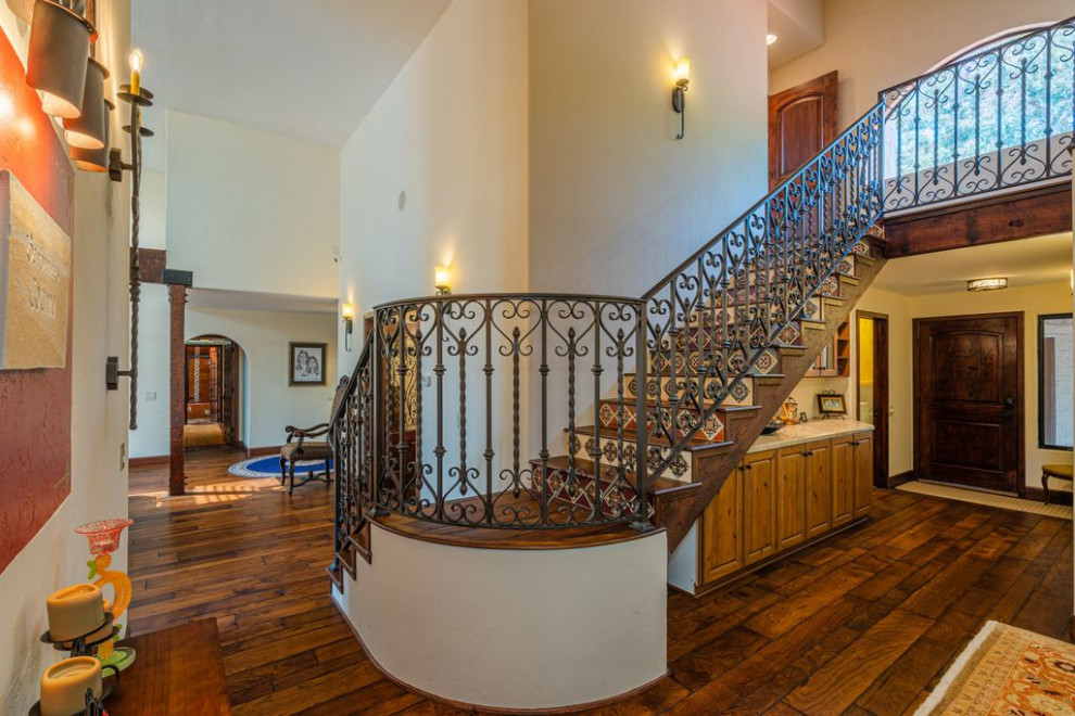 Пример оригинального дизайна: лестница в стиле фьюжн с деревянными ступенями, подступенками из плитки и металлическими перилами