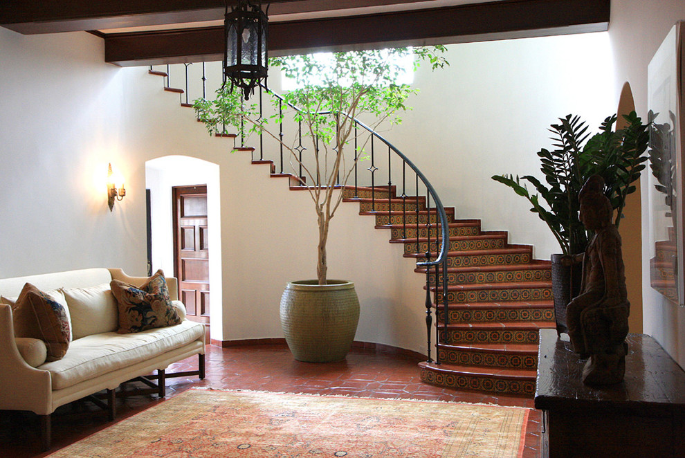 Источник вдохновения для домашнего уюта: изогнутая лестница в средиземноморском стиле с ступенями из плитки и подступенками из плитки