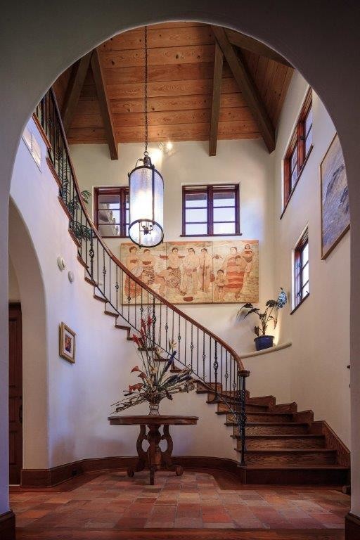 Идея дизайна: большая изогнутая деревянная лестница в средиземноморском стиле с деревянными ступенями