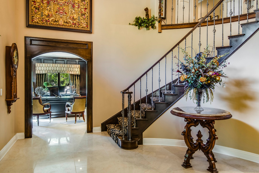 This is an example of a large mediterranean carpeted curved staircase in Los Angeles with carpeted risers.
