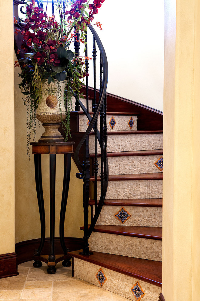 Modelo de escalera curva mediterránea con escalones de madera y contrahuellas con baldosas y/o azulejos