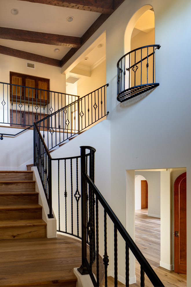 Стильный дизайн: большая угловая деревянная лестница в средиземноморском стиле с деревянными ступенями и металлическими перилами - последний тренд