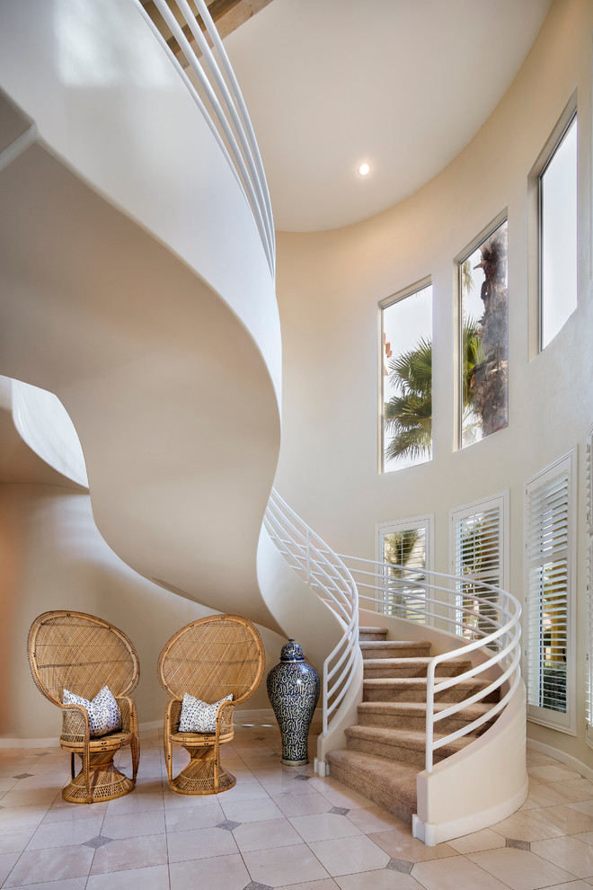 Island style carpeted curved staircase photo in Los Angeles with carpeted risers