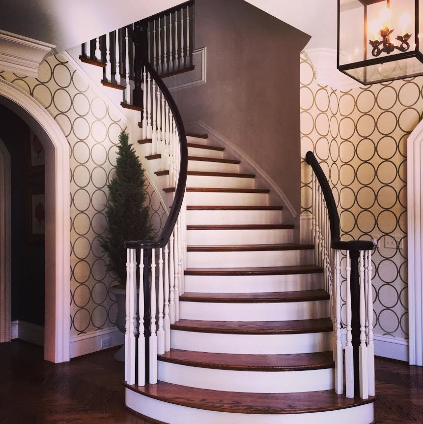 Idées déco pour un grand escalier peint hélicoïdal classique avec des marches en bois et un garde-corps en bois.