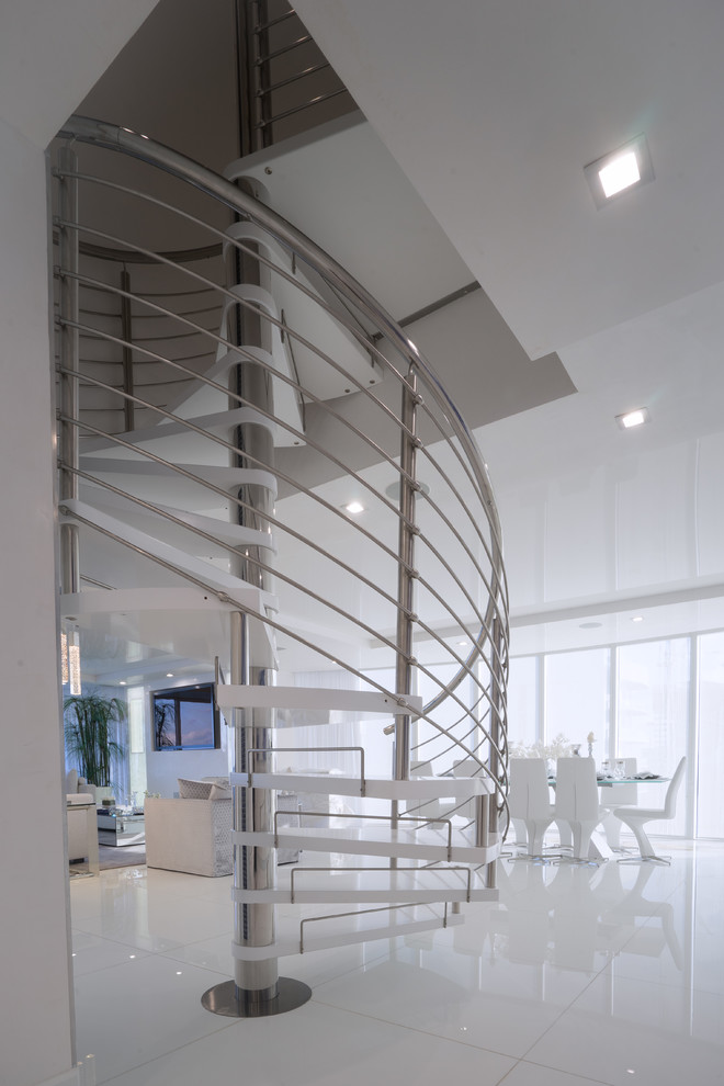 Exemple d'un escalier sans contremarche hélicoïdal moderne de taille moyenne avec des marches en bois peint et un garde-corps en métal.