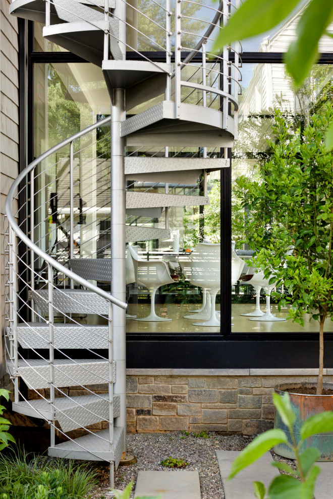 Imagen de escalera de caracol pequeña con escalones de metal, contrahuellas de metal y barandilla de metal