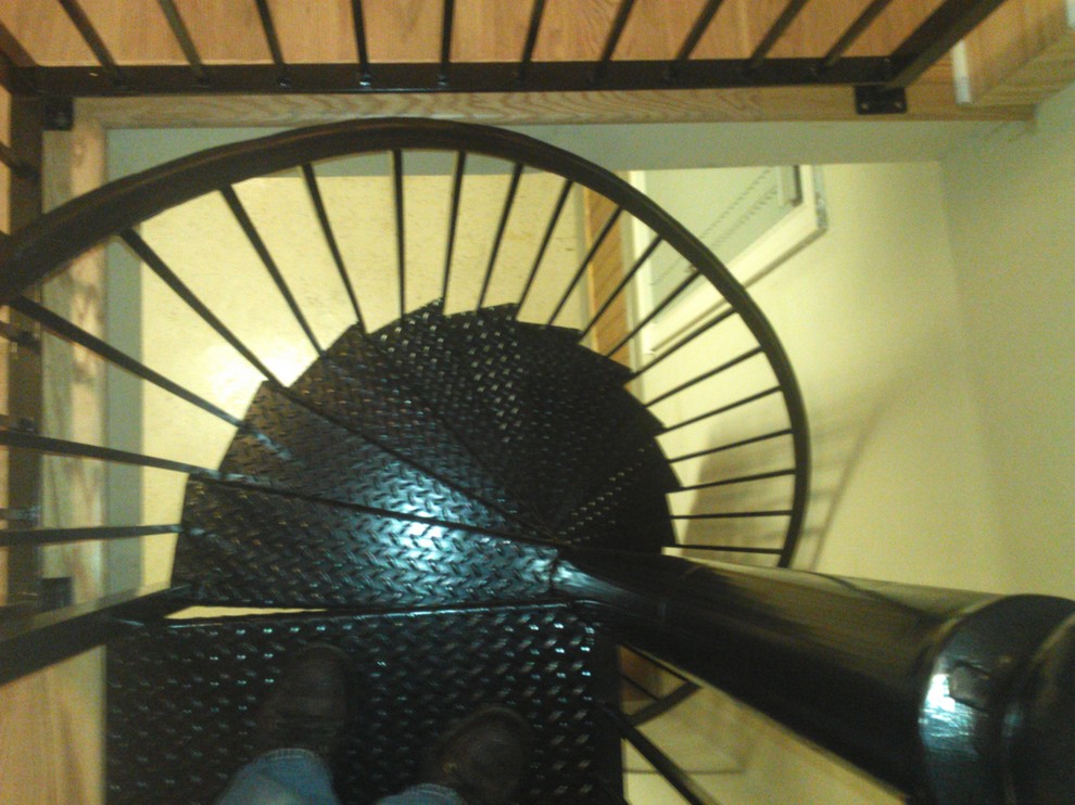 Ejemplo de escalera de caracol mediterránea de tamaño medio con escalones de metal y contrahuellas de metal