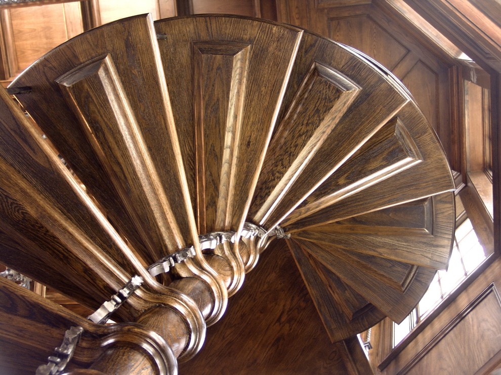 Esempio di una scala a chiocciola minimalista con pedata in legno e nessuna alzata