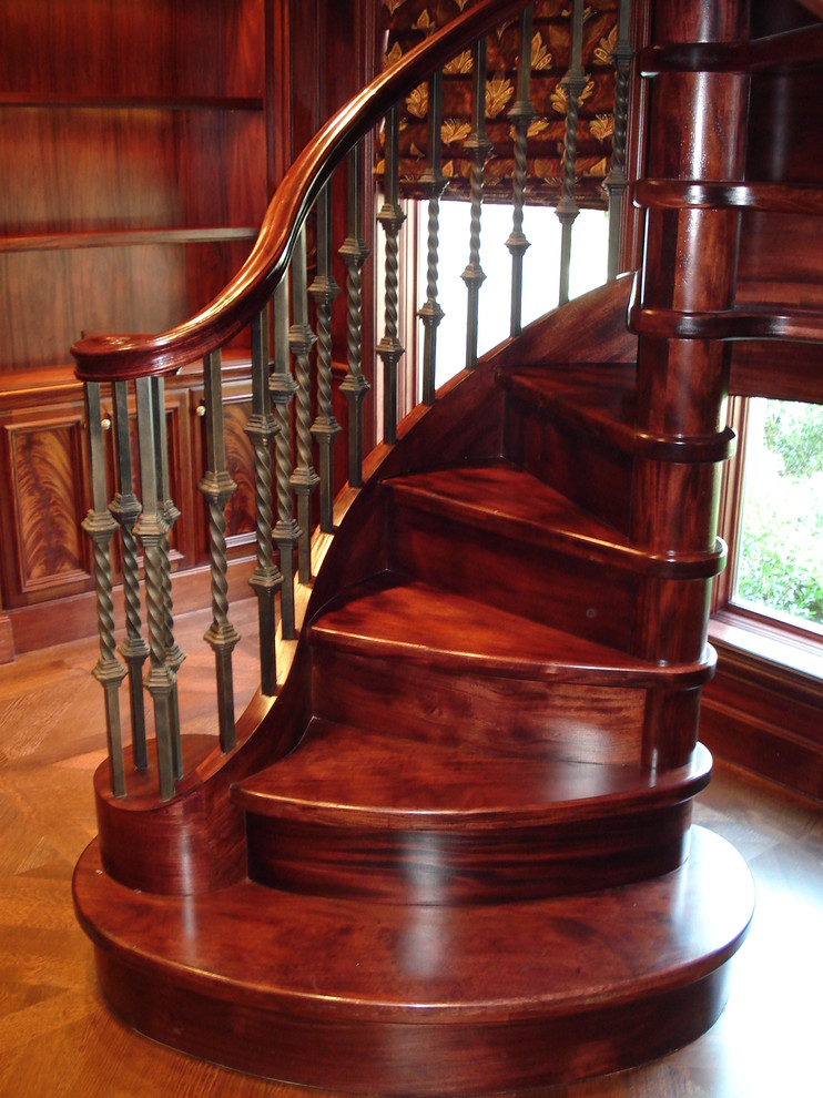 Aménagement d'un escalier hélicoïdal classique avec des marches en bois et des contremarches en bois.