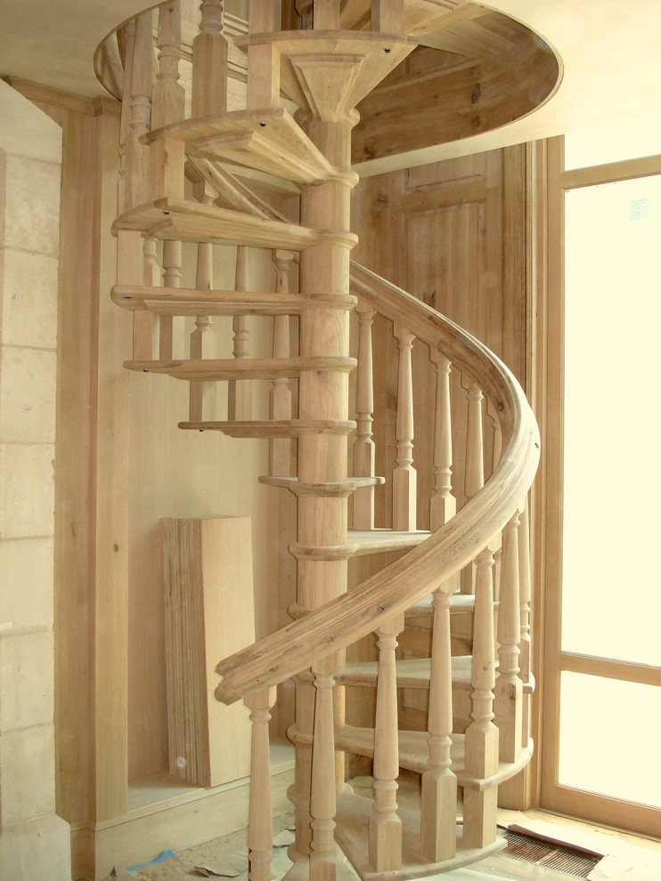 Immagine di una scala a chiocciola classica con pedata in legno e alzata in legno