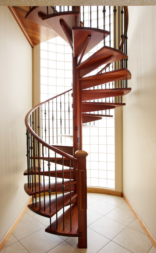 Foto de escalera de caracol moderna con escalones de madera, contrahuellas de madera y barandilla de varios materiales