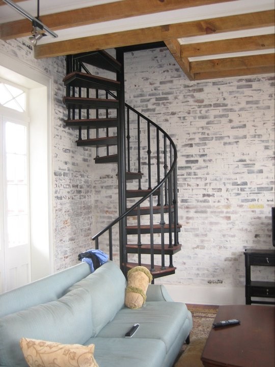 Réalisation d'un escalier sans contremarche hélicoïdal design de taille moyenne avec des marches en bois et éclairage.