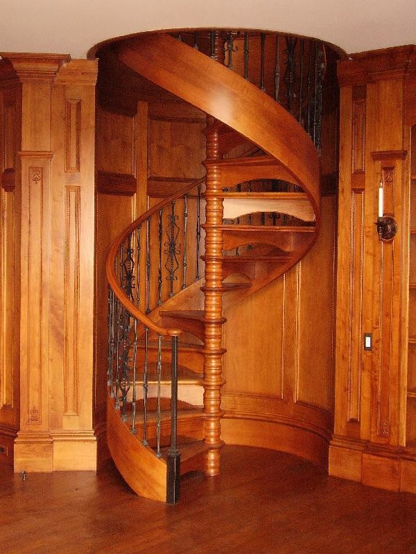 На фото: винтовая деревянная лестница среднего размера в классическом стиле с деревянными ступенями с