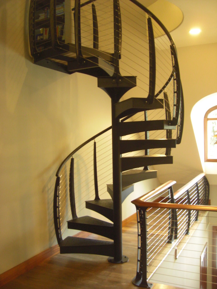 Diseño de escalera de caracol moderna sin contrahuella con escalones de madera y barandilla de metal