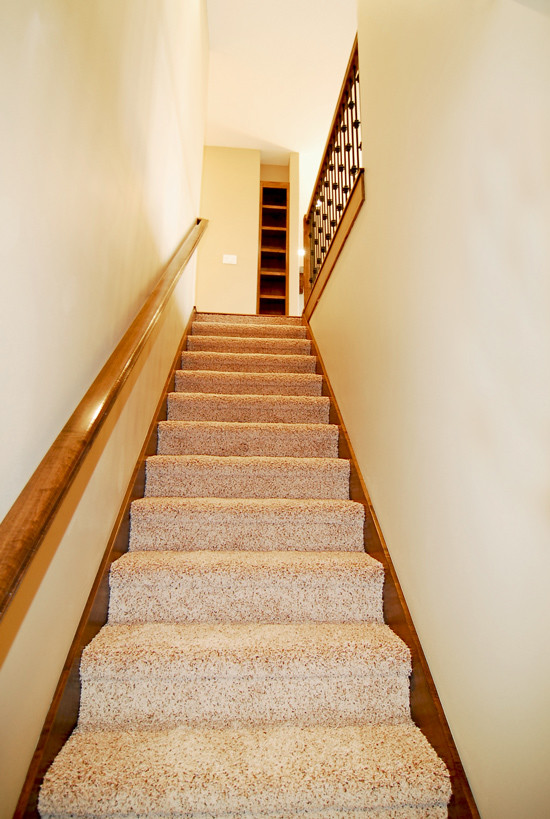 На фото: маленькая прямая лестница в стиле кантри с ступенями с ковровым покрытием и ковровыми подступенками для на участке и в саду