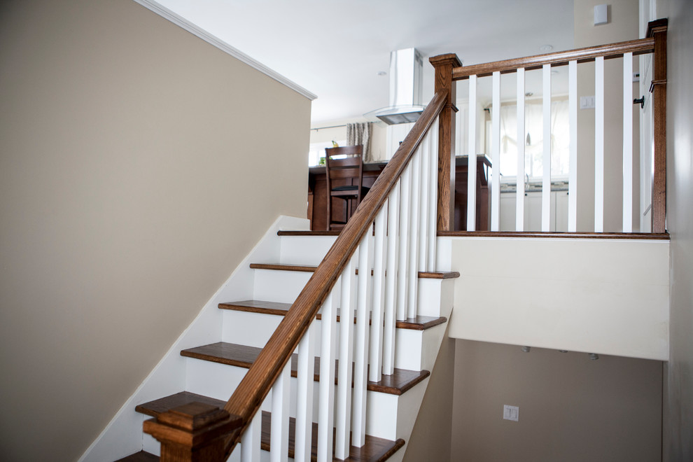 Medium sized classic wood straight staircase in Other with painted wood risers.