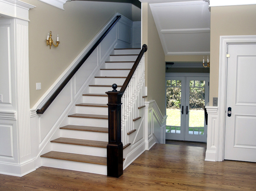 This is an example of a medium sized classic wood u-shaped wood railing staircase in New York with painted wood risers.