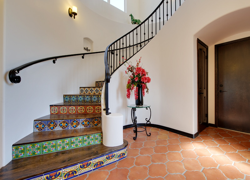 Foto de escalera curva mediterránea con escalones de madera y contrahuellas con baldosas y/o azulejos