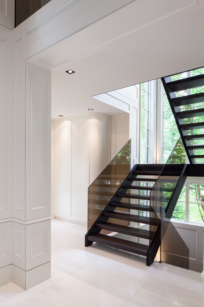 Exemple d'un grand escalier sans contremarche tendance en U avec des marches en bois et un garde-corps en verre.