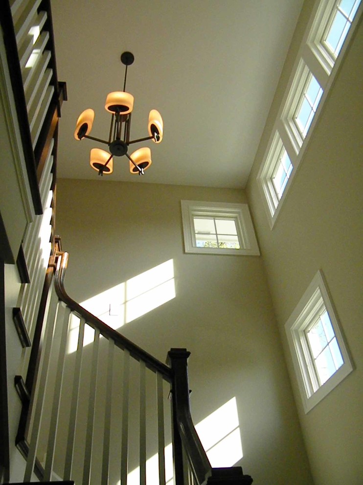Foto de escalera curva de estilo americano de tamaño medio con escalones de madera, contrahuellas de madera, barandilla de madera y papel pintado
