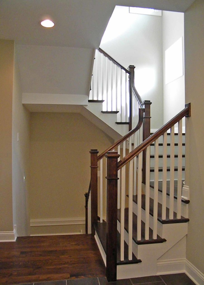 Idée de décoration pour un escalier courbe craftsman de taille moyenne avec des marches en bois, des contremarches en bois, un garde-corps en bois et du papier peint.