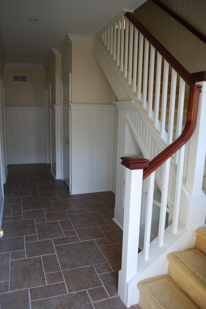 Ejemplo de escalera recta clásica grande con escalones enmoquetados, contrahuellas enmoquetadas y barandilla de madera
