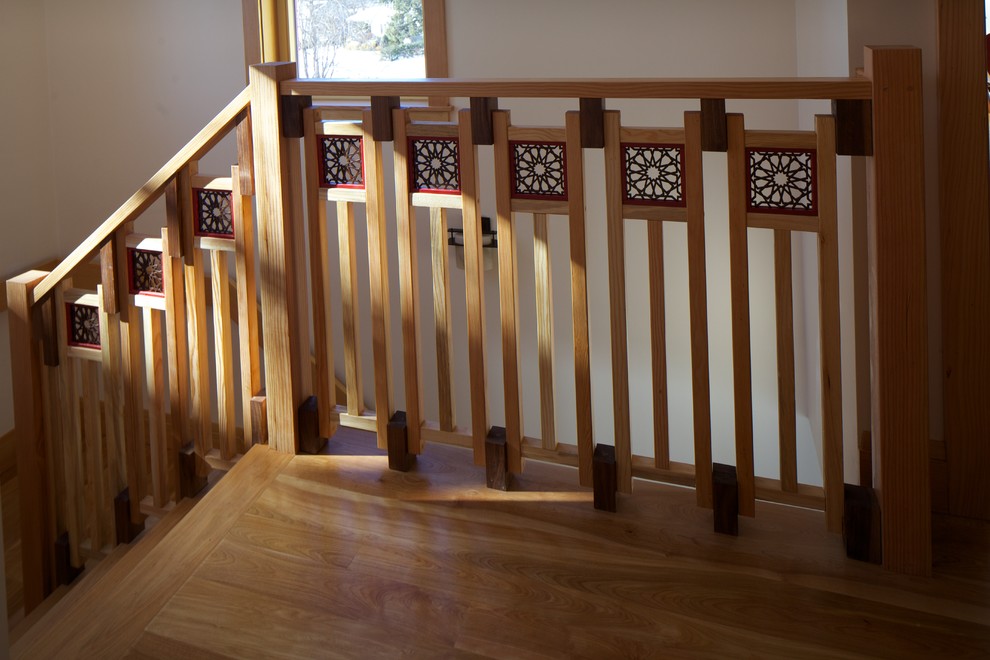 На фото: большая п-образная деревянная лестница в современном стиле с деревянными ступенями и деревянными перилами с