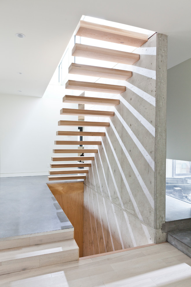 Cette photo montre un grand escalier sans contremarche flottant moderne avec des marches en bois.