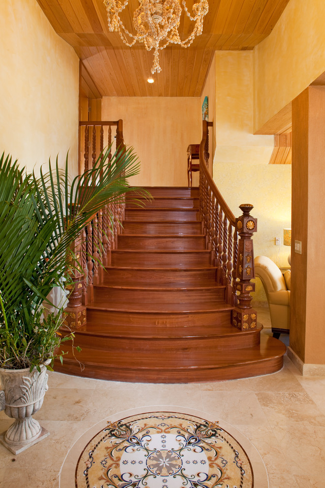 Diseño de escalera curva mediterránea de tamaño medio con escalones de madera, contrahuellas de madera y barandilla de madera