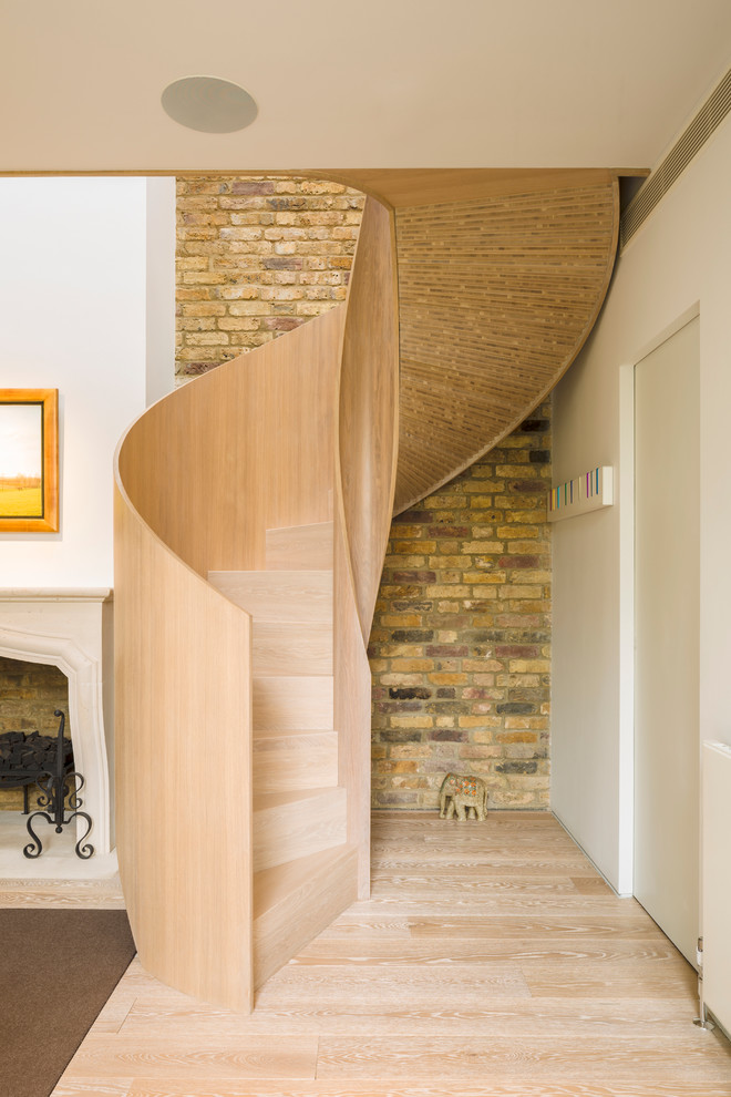 Design ideas for a contemporary wood spiral staircase in London with wood risers.