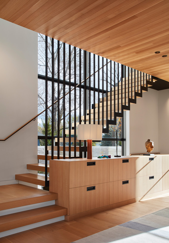 Idées déco pour un escalier sans contremarche contemporain en L avec des marches en bois, un garde-corps en métal et éclairage.