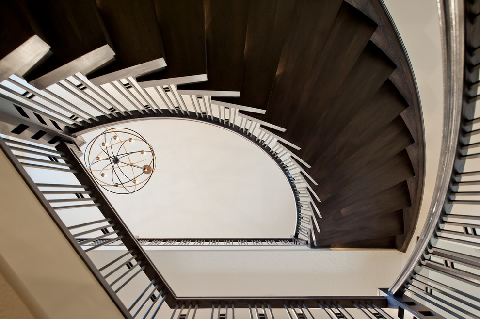 Cette image montre un escalier courbe design avec des marches en bois et des contremarches en bois.
