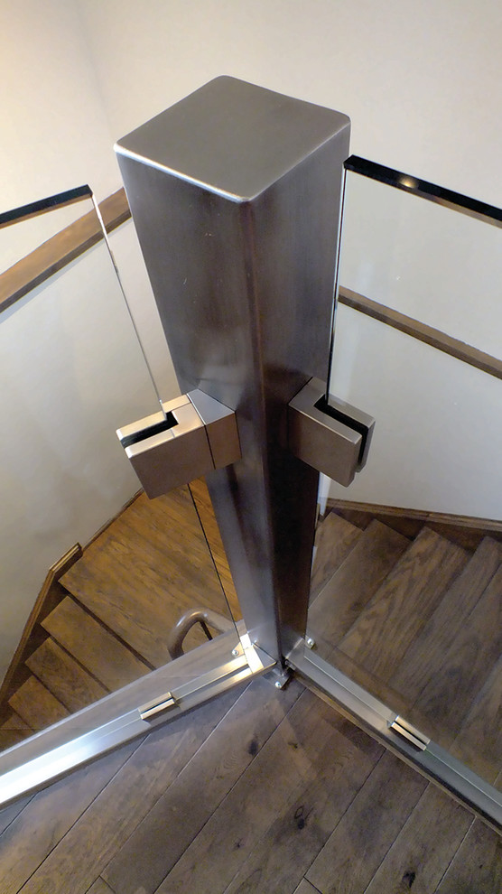 Cette photo montre un escalier moderne en L de taille moyenne avec des marches en bois, des contremarches en bois et un garde-corps en verre.