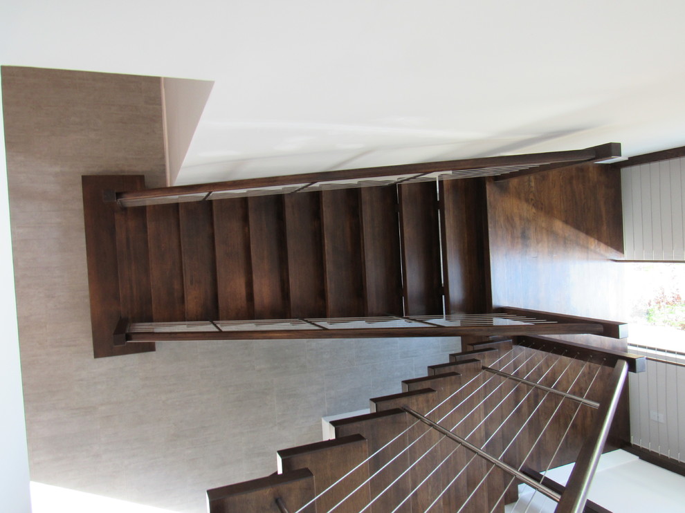 Ejemplo de escalera suspendida actual extra grande sin contrahuella con escalones de madera y barandilla de cable