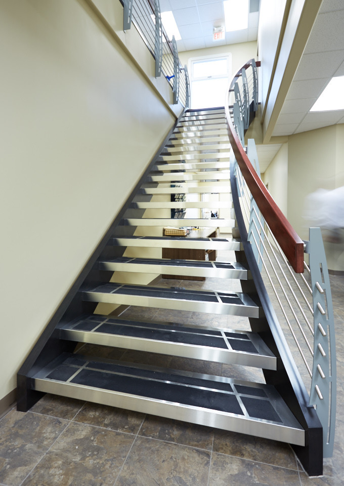 Aménagement d'un escalier sans contremarche courbe industriel avec des marches en métal.