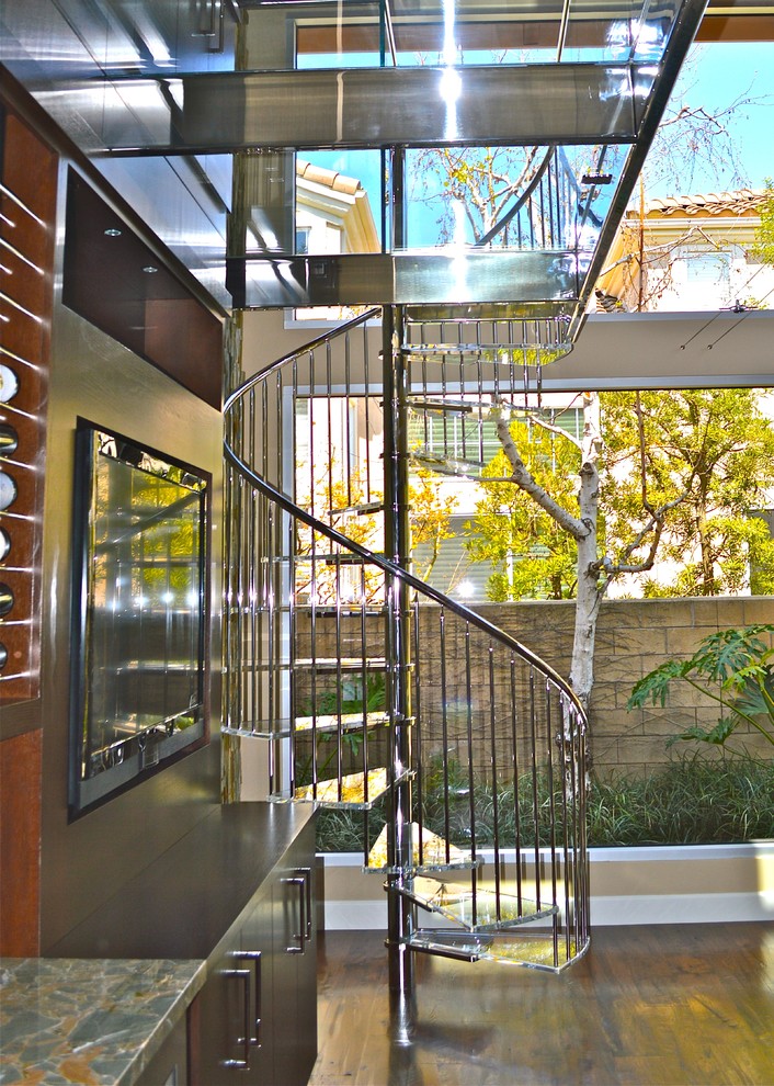 This is an example of a medium sized modern glass spiral staircase in Orange County with open risers.