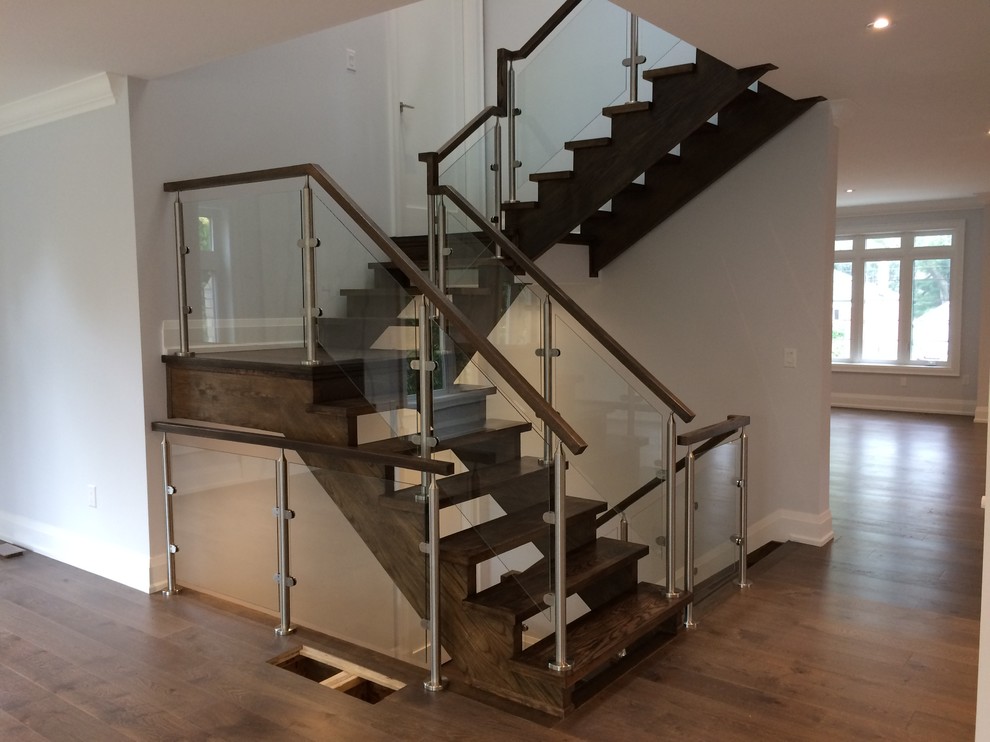 Foto de escalera suspendida actual sin contrahuella con escalones de madera y barandilla de vidrio