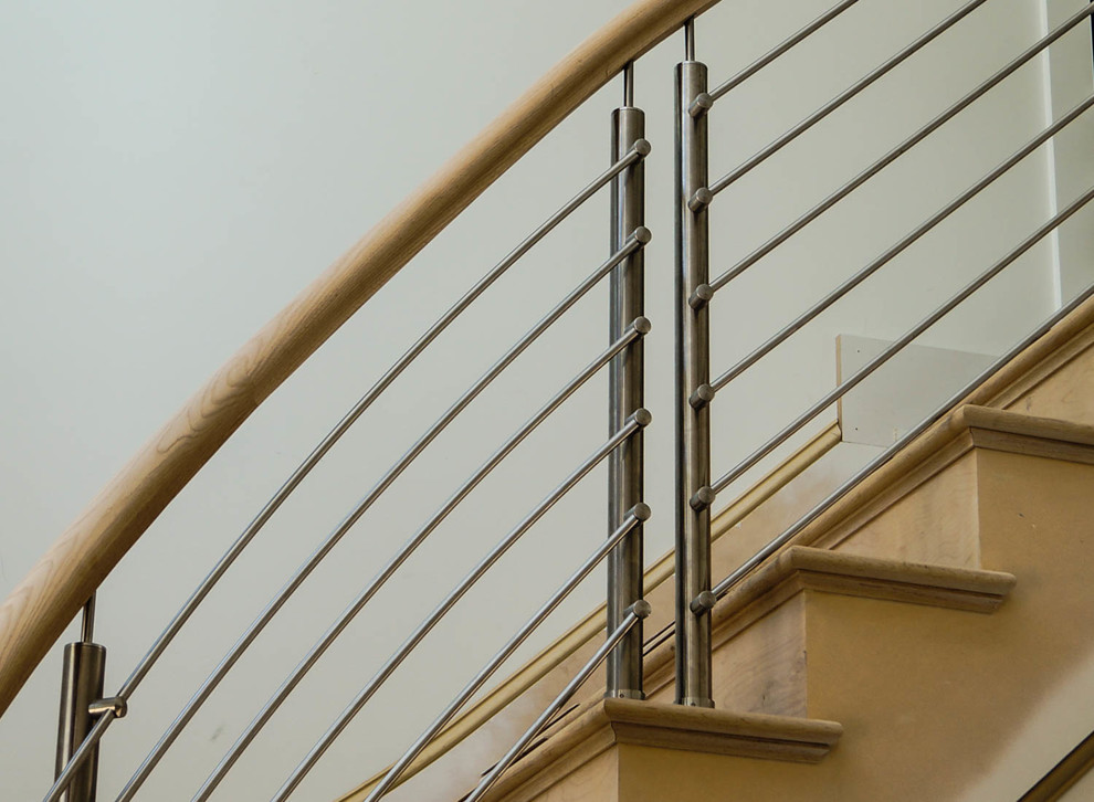 Стильный дизайн: изогнутая деревянная лестница в стиле модернизм с деревянными ступенями - последний тренд