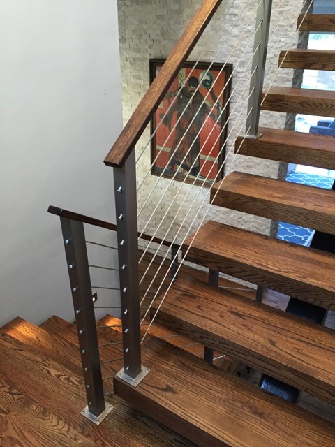 Idee per una scala a rampa dritta moderna di medie dimensioni con pedata in legno e nessuna alzata