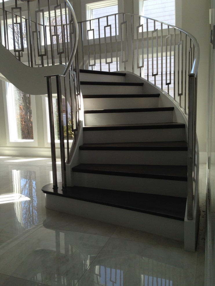 Стильный дизайн: изогнутая лестница среднего размера в современном стиле с деревянными ступенями и крашенными деревянными подступенками - последний тренд