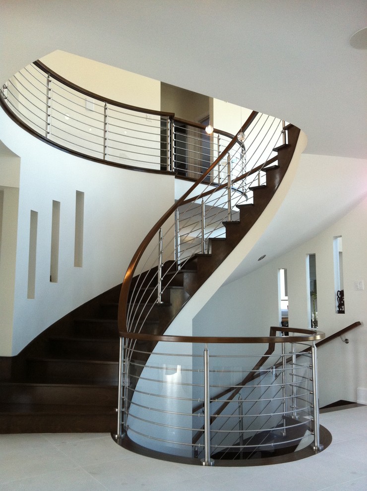 Photo of a contemporary wood curved staircase in Montreal with wood risers.