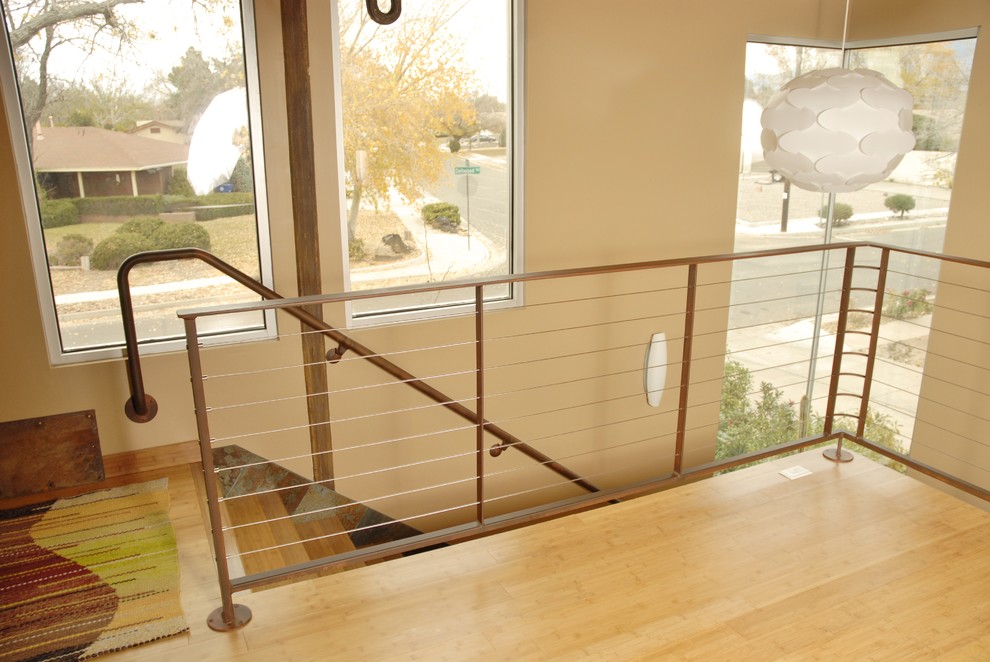 Cette photo montre un escalier industriel en L avec des marches en bois et un garde-corps en métal.