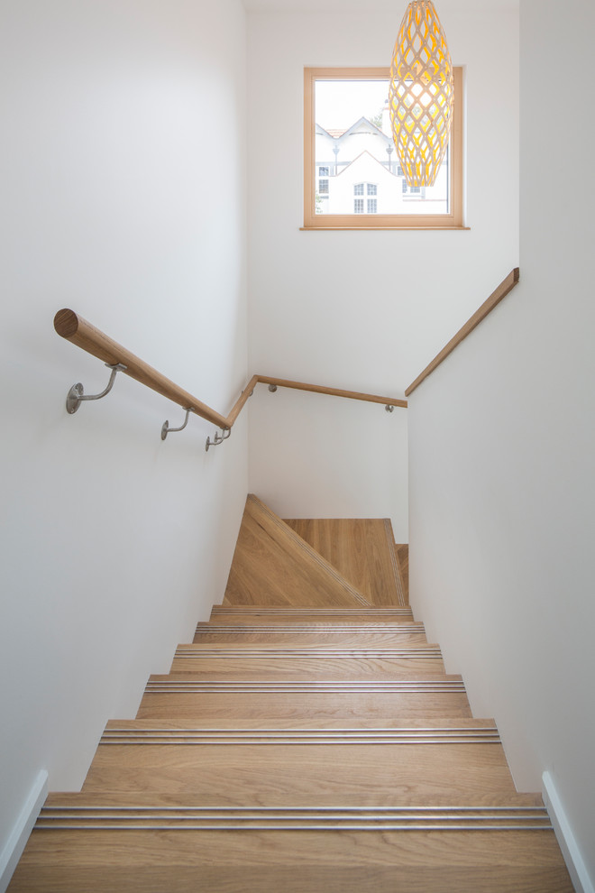 ダニーデンにある低価格の中くらいなコンテンポラリースタイルのおしゃれな折り返し階段 (木の蹴込み板、木材の手すり) の写真