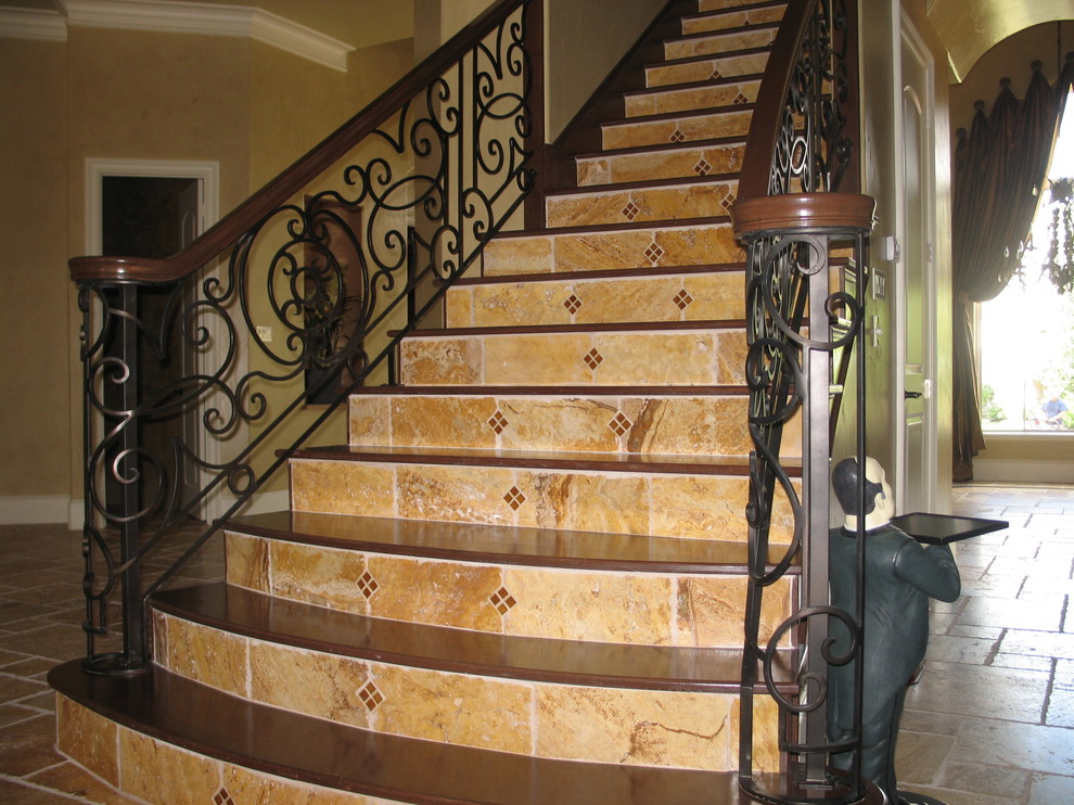 Photo of a large mediterranean wood straight staircase in Houston with tiled risers.