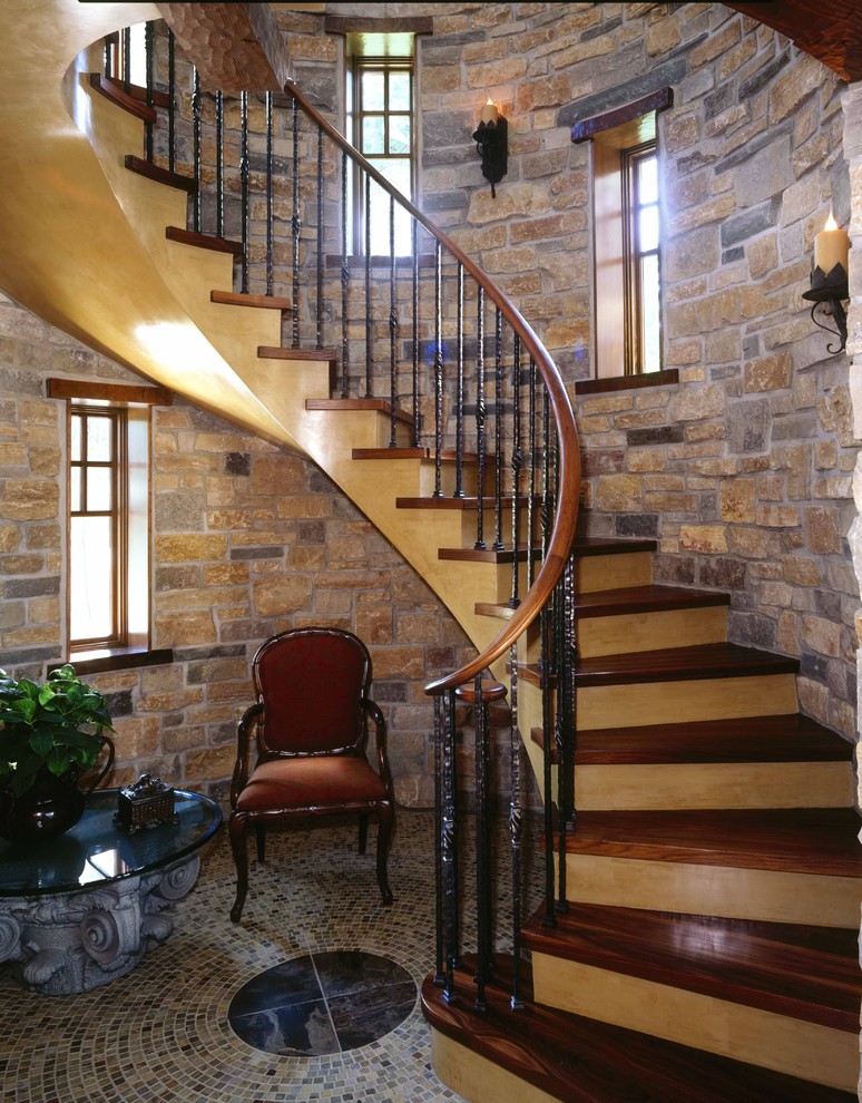 На фото: изогнутая деревянная лестница среднего размера в классическом стиле с деревянными ступенями и деревянными перилами