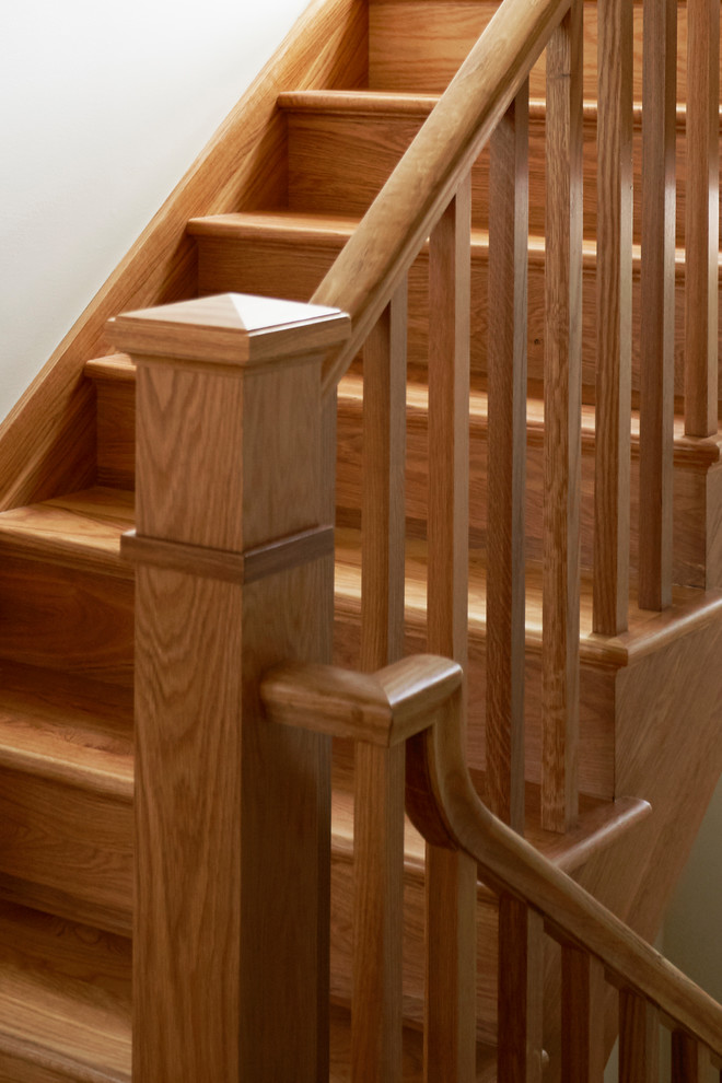 Medium sized rustic wood u-shaped wood railing staircase in Chicago with wood risers.