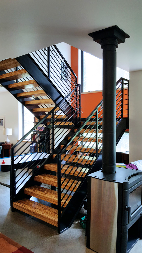 Ejemplo de escalera en U contemporánea de tamaño medio sin contrahuella con escalones de madera y barandilla de metal