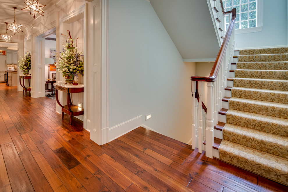 This is an example of a large rural wood u-shaped staircase in DC Metro with painted wood risers.