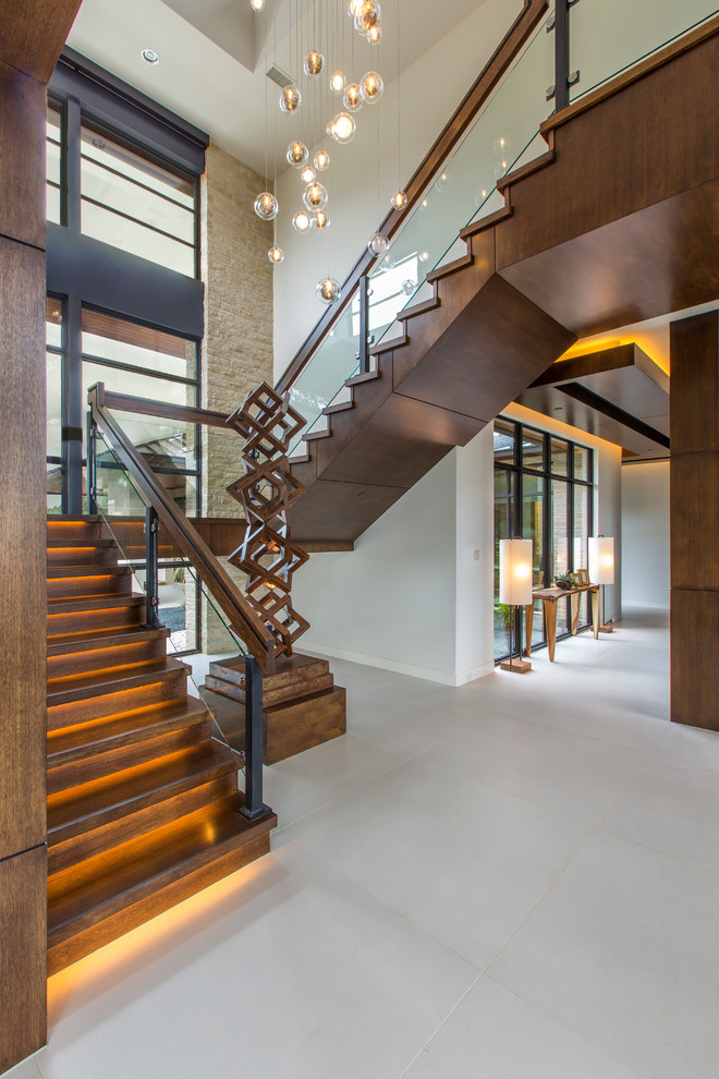 Cette image montre un escalier design en U avec des marches en bois, des contremarches en bois, un garde-corps en matériaux mixtes et palier.