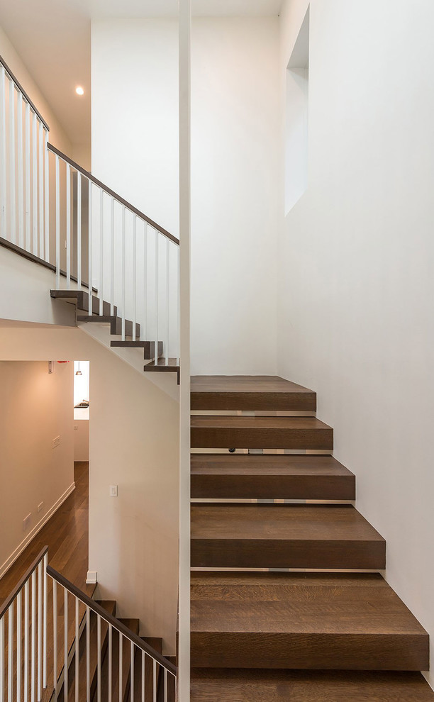 Cette photo montre un grand escalier tendance en U avec des marches en bois et des contremarches en métal.